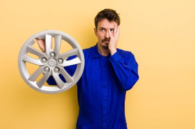 Sıkılmış, hayal kırıklığına uğramış ve yorgun hisseden bir adam. araba tamircisi konsepti