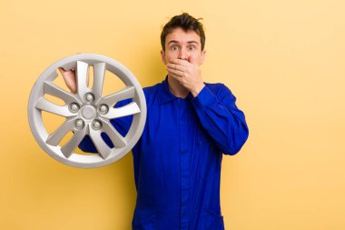 Adam şok olmuş bir şekilde elleri ile ağzını kapatıyor. araba tamircisi konsepti