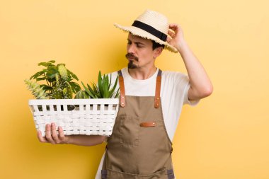 Kafası karışmış, kafası karışmış, kaşınan bir adam. Bahçıvan konsepti