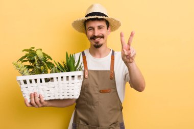 Gülümseyen ve mutlu görünen bir adam zafer ya da barış işareti yapar. Bahçıvan konsepti