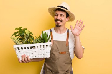 Mutlu bir şekilde gülümseyen, el sallayan, seni selamlayan bir adam. Bahçıvan konsepti