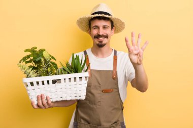 Adam gülümsüyor ve arkadaş canlısı görünüyor, dört numarayı gösteriyor. Bahçıvan konsepti