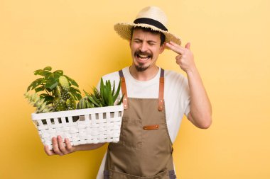 Adam mutsuz ve stresli görünüyor, intihar jesti silah işareti yapıyor. Bahçıvan konsepti