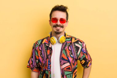 Mutlu bir şekilde gülümsüyor, eli kalçasında ve kendinden emin bir şekilde. müzik konseptini dinlemek