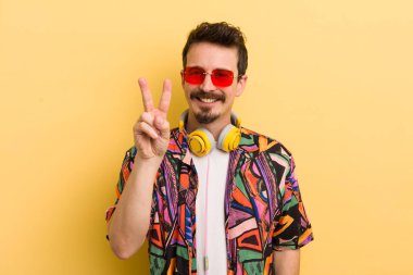 Gülümseyen ve mutlu görünen, zafer ya da barış işareti yapan. müzik konseptini dinlemek