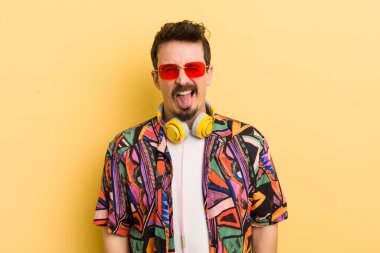 Neşeli ve asi bir tavırla, şakalar yaparak ve dil çıkararak. müzik konseptini dinlemek