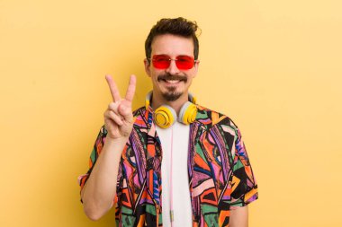 Gülümsüyor ve dost canlısı görünüyor, iki numarayı gösteriyor. müzik konseptini dinlemek