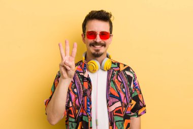 Gülümsüyor ve arkadaş canlısı görünüyor, üç numarayı gösteriyor. müzik konseptini dinlemek