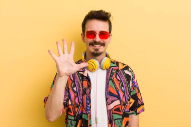 Gülümsüyor ve arkadaş canlısı görünüyor, beş numarayı gösteriyor. müzik konseptini dinlemek