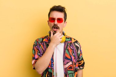 Ağzı ve gözleri açık ve elleri çenesinde. müzik konseptini dinlemek