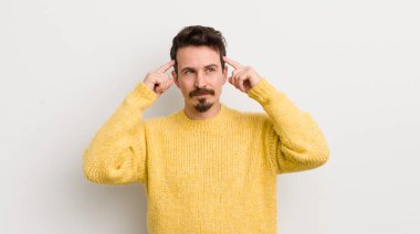 Hispanik genç adam kafası karışık ya da şüpheci, bir fikre odaklanmış, çok düşünüyor, kenarda boşluğu kopyalamak istiyor.