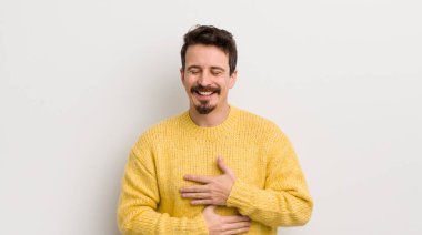 İspanyol genç adam komik bir şakaya yüksek sesle gülüyor, mutlu ve neşeli hissediyor, eğleniyor.