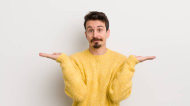 İspanyol genç adam şaşkın ve kafası karışık, şüpheci, farklı seçenekleri tartıyor ya da komik bir ifadeyle seçiyor.