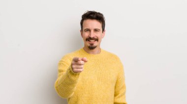 İspanyol genç adam kameraya tatmin olmuş, kendinden emin, dost canlısı bir gülümsemeyle bakıyor ve seni seçiyor.