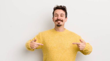 İspanyol genç adam gururlu, kibirli, mutlu, şaşırmış ve tatmin olmuş görünüyor, kendini gösteriyor, kendini kazanan gibi hissediyor.