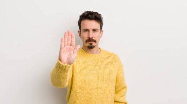 İspanyol genç adam ciddi, sert, hoşnutsuz ve kızgın görünüyor.