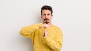 İspanyol genç adam ciddi, sert, kızgın ve canı sıkkın görünüyor.