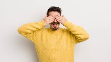 İspanyol genç adam gülümsüyor ve mutlu hissediyor, iki eliyle gözlerini kapatıyor ve inanılmaz bir sürpriz bekliyor.