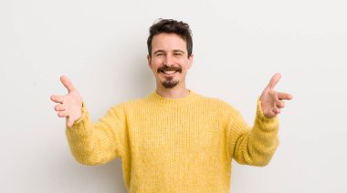 İspanyol genç adam neşeyle gülümsüyor sıcak, dostça, sevgi dolu bir kucak veriyor, mutlu ve sevimli hissediyor.