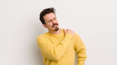 İspanyol genç adam yorgun, stresli, endişeli, hayal kırıklığına uğramış ve depresyonda, sırtı ya da boynu ağrıyan