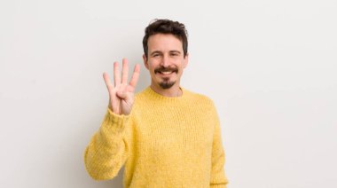 İspanyol genç adam gülümsüyor ve arkadaş canlısı görünüyor. Elleri önde, geriye doğru sayıyor.