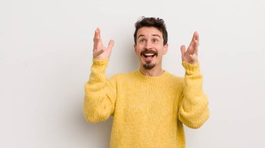 İspanyol genç adam kendini mutlu, şaşkın, şanslı ve şaşırmış hissediyor. Zaferi kutlarken iki eli havada.