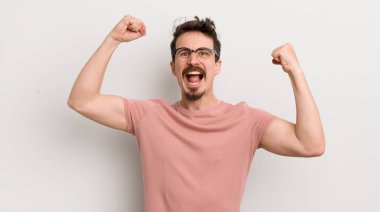 İspanyol genç adam muzaffer bir şekilde bağırıyor. Heyecanlı, mutlu ve şaşırmış görünüyor. Kutlama yapıyor.
