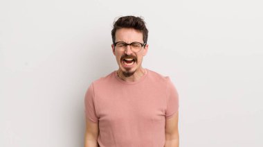 İspanyol genç adam agresif bir şekilde bağırıyor, çok kızgın, hayal kırıklığına uğramış, öfkeli ya da sinirli görünüyor, hayır