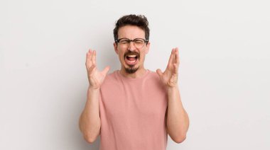 İspanyol genç adam öfkeyle bağırıyor, stresli hissediyor ve ellerini havaya kaldırıp neden ben diye bağırıyor.