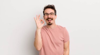 İspanyol genç adam kendini başarılı ve tatmin olmuş hissediyor, ağzı açık gülümsüyor, elle imza atıyor.