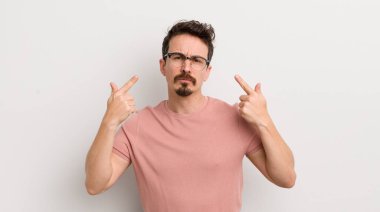 İspanyol asıllı, kötü tavırlı, gururlu ve agresif görünen, yukarıyı gösteren ya da elleriyle işaret eden genç bir adam.