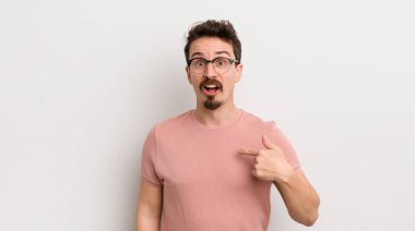 Şok olmuş ve ağzı açık, kendini işaret eden İspanyol genç bir adam.