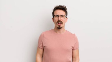 İspanyol genç adam korkmuş ve şok olmuş hissediyor, ağzı açık şaşkınlık içinde.