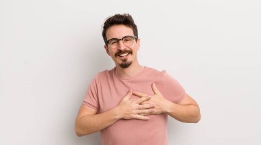 İspanyol genç adam romantik, mutlu ve aşık, neşeyle gülümsüyor ve kalbe yakın el ele tutuşuyor.