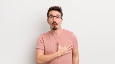 İspanyol genç adam şok olmuş ve şaşırmış hissediyor, gülümsüyor, el ele tutuşuyor, o olmaktan mutlu ya da minnettarlık gösteriyor.