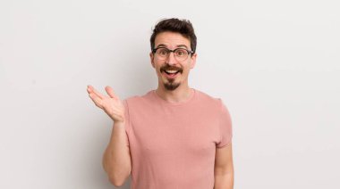 İspanyol genç adam mutlu, şaşırmış ve neşeli hissediyor, olumlu bir tavırla gülümsüyor, bir çözüm ya da fikri fark ediyor.