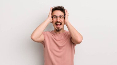İspanyol genç adam ellerini kaldırıyor, ağzı açık, son derece şanslı, şaşırmış, heyecanlı ve mutlu.