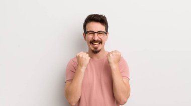 İspanyol genç adam zaferle bağırıyor, gülüyor, mutlu ve heyecanlı hissediyor ve başarıyı kutluyor.