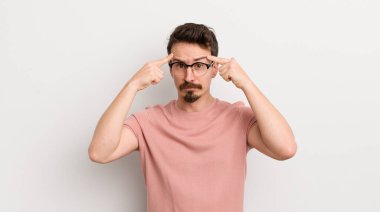 Ciddi ve konsantre görünümlü, beyin fırtınası yapan ve zorlu bir sorunu düşünen İspanyol genç adam.