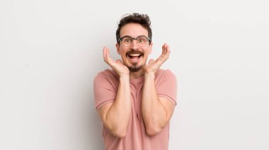 İspanyol genç adam beklenmedik bir sürprizden dolayı şaşkın, heyecanlı, gülen, şaşkın ve mutlu hissediyor.