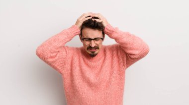 İspanyol genç adam kendini stresli ve hayal kırıklığına uğramış hissediyor, elele tutuşuyor, yorgun, mutsuz ve migren ağrısı çekiyor.