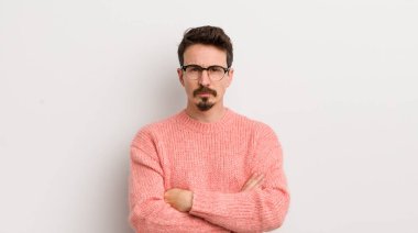 İspanyol genç adam hayal kırıklığına uğramış, hayal kırıklığına uğramış, ciddi görünüyor, kızgın ve kollarını kavuşturmuş.