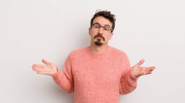 İspanyol genç adam şaşkın ve şaşkın hissediyor, doğru cevap ya da karardan emin değil, bir seçim yapmaya çalışıyor.