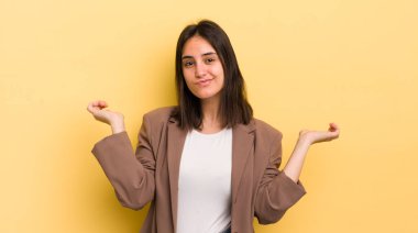 Genç İspanyol kadın şaşkın ve kafası karışık, şüpheci, farklı seçenekleri tartıyor veya komik bir ifadeyle seçiyor.