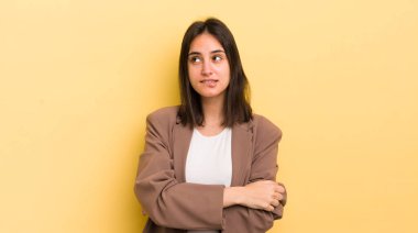 Genç İspanyol kadın şüpheye düşüyor ya da düşünüyor, dudağını ısırıyor ve kendini güvensiz ve gergin hissediyor, kenarda yer arıyor.