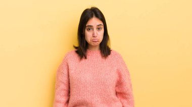 Genç İspanyol kadın üzgün ve mızmızlanıyor, mutsuz bir bakışla, negatif ve hayal kırıklığına uğramış bir tavırla ağlıyor.