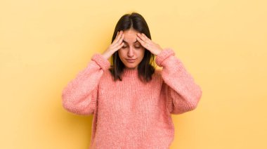 Genç İspanyol kadın stresli ve hayal kırıklığına uğramış görünüyor. Baskı altında, baş ağrısı ve sorunlarıyla çalışıyor.