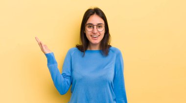 Genç İspanyol kadın mutlu, şaşırmış ve neşeli hissediyor, olumlu bir tavırla gülümsüyor, bir çözüm ya da fikri fark ediyor.