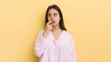 Şaşırmış, gergin, endişeli ya da korkmuş bakışları olan genç İspanyol kadın fotokopi alanına doğru yan bakıyor.