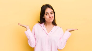 Genç İspanyol kadın şaşkın ve kafası karışık, şüpheci, farklı seçenekleri tartıyor veya komik bir ifadeyle seçiyor.